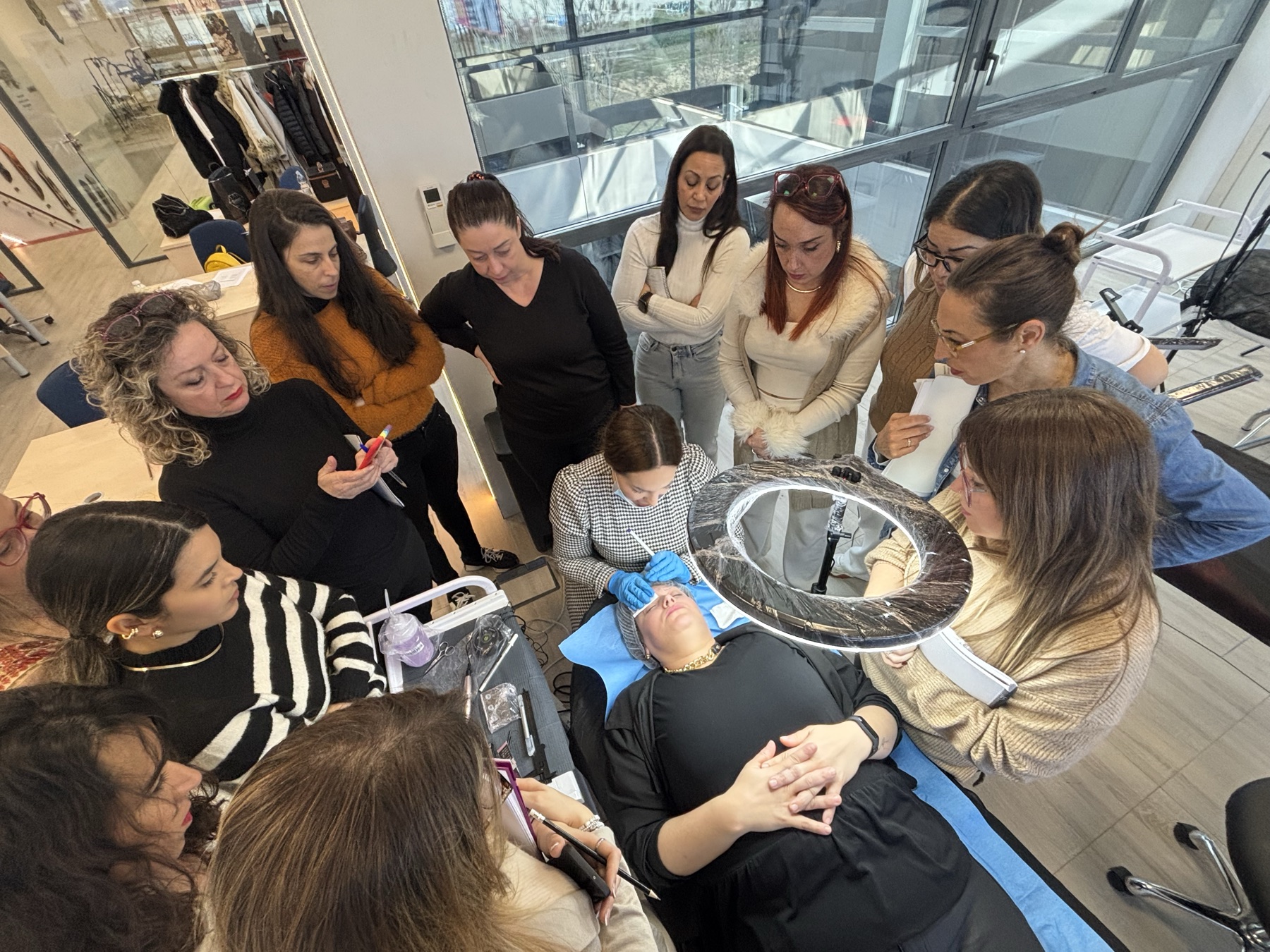 Demostración práctica con alumnas alrededor de una camilla